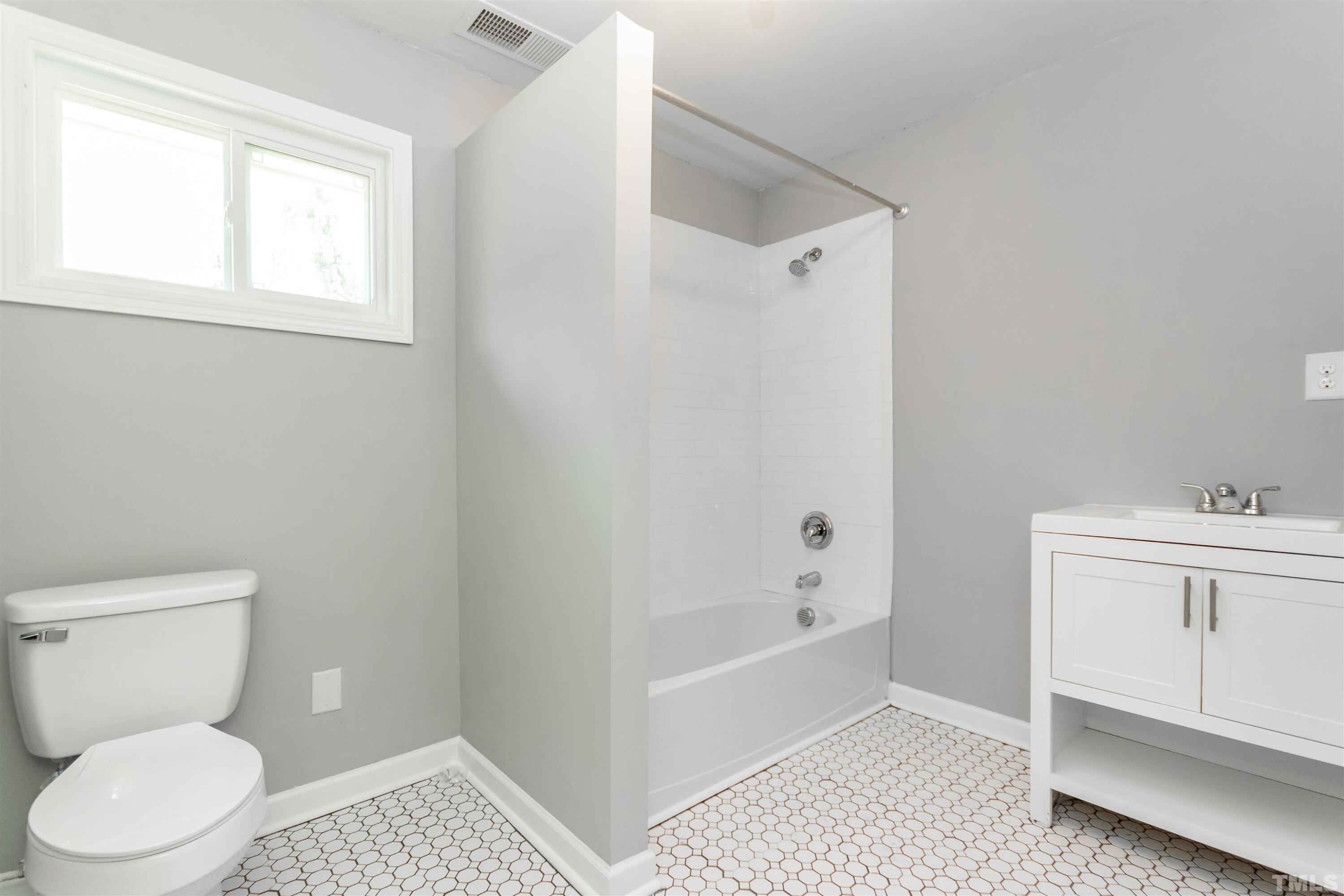 708 Bailey Drive Raleigh, NC 27610 - Photo 10 of 10 a bathroom with a toilet a sink a window and vanity