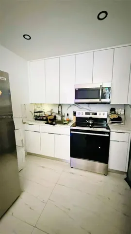 a kitchen with stainless steel appliances a stove a sink and a microwave