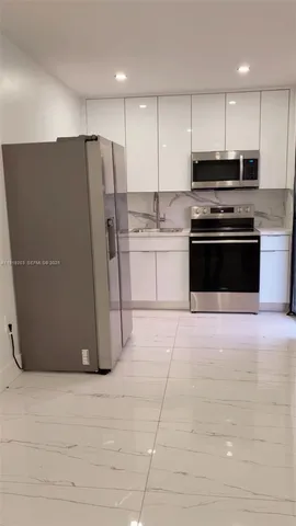 a kitchen with stainless steel appliances granite countertop a refrigerator a sink and a stove