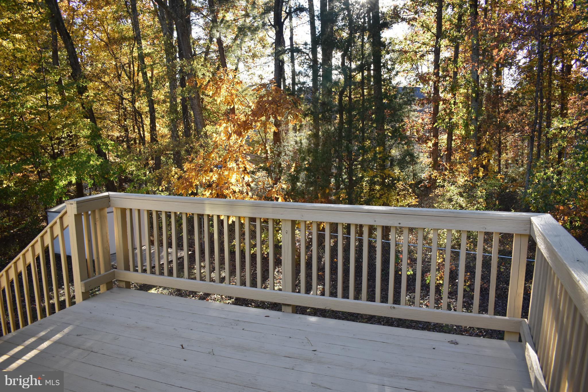 Deck overlooks private fenced yard and trees