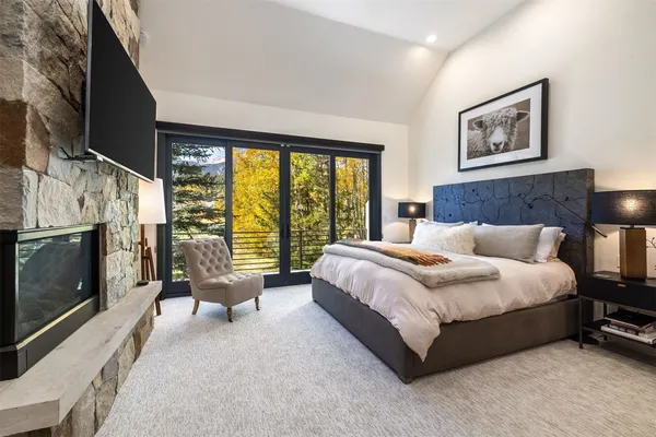a spacious bedroom with a bed and a flat screen tv
