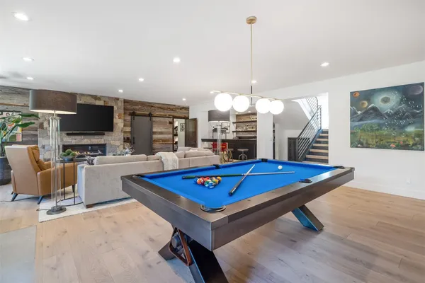 a kitchen with stainless steel appliances granite countertop a table chairs stove and cabinets