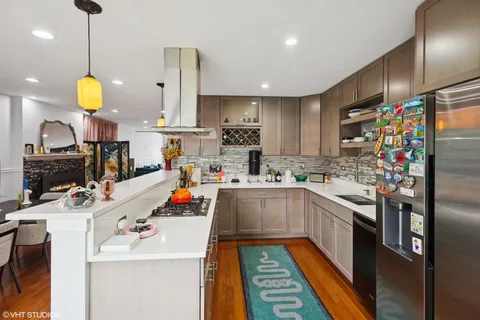 a kitchen with stainless steel appliances a stove a sink and a refrigerator