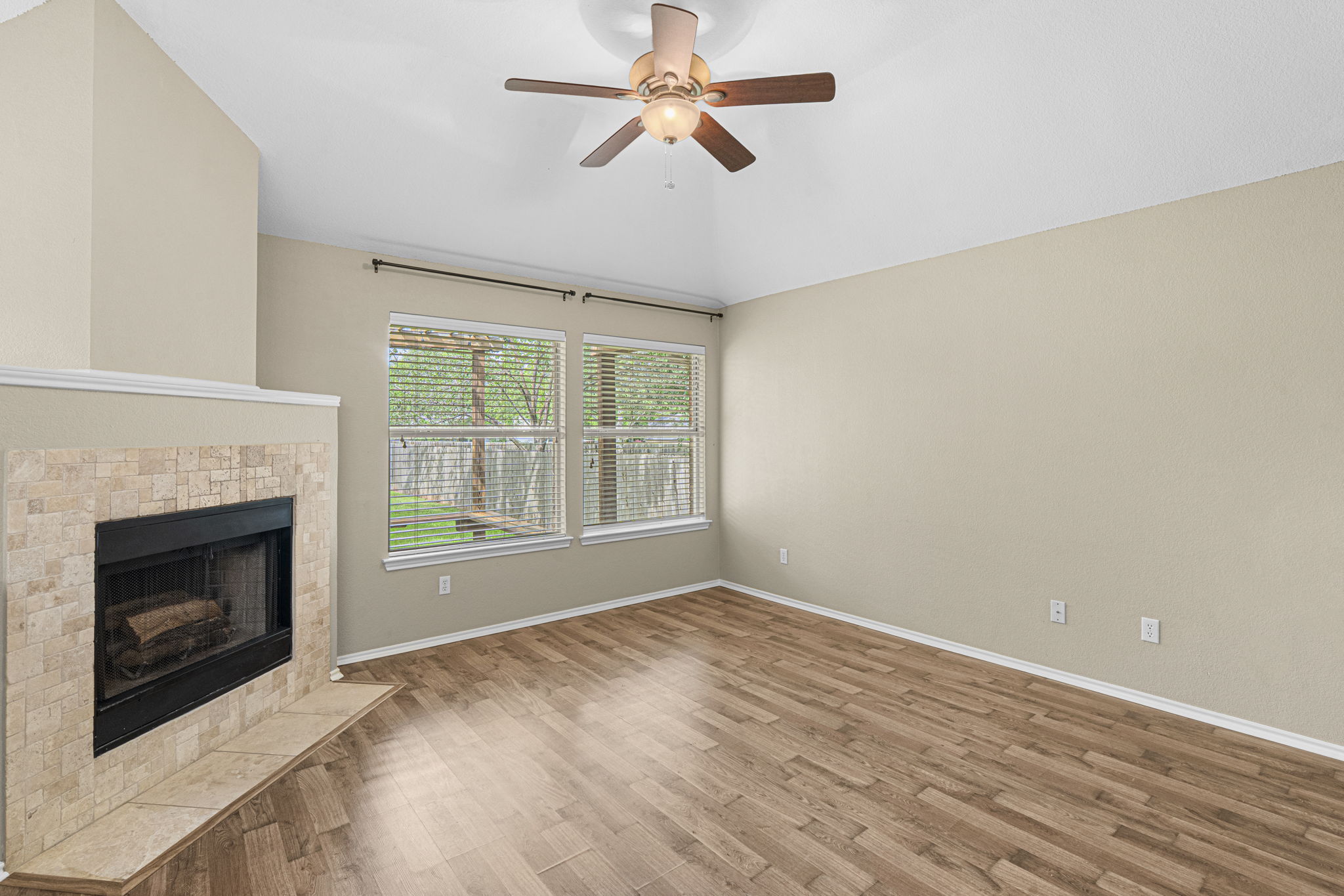 7172 Ridge Oak Road Austin, TX 78749 - Photo 26 of 40 A well-lit living area features a charming fireplace and warm wood flooring.