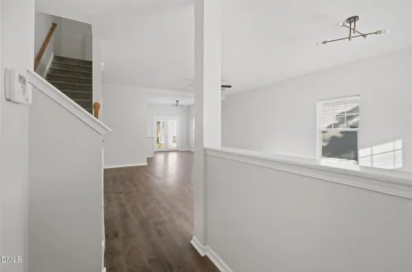 a view of a hallway with wooden floor and staircase