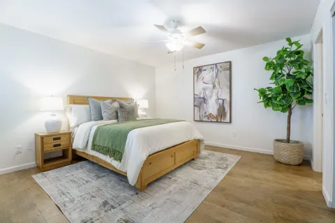 a bedroom with a large bed and a potted plant