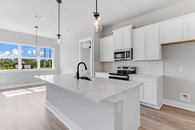 a kitchen with stainless steel appliances a sink stove and microwave