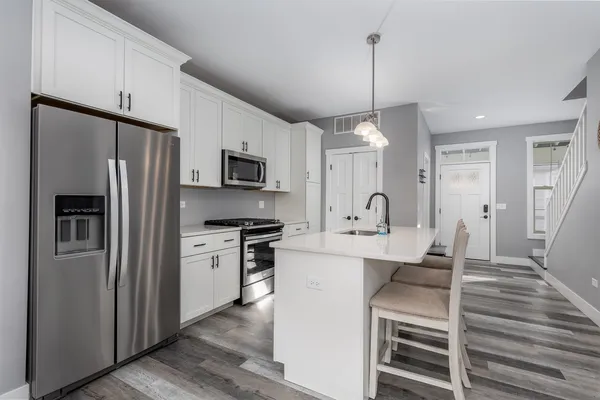 a kitchen with white cabinets stainless steel appliances and a sink
