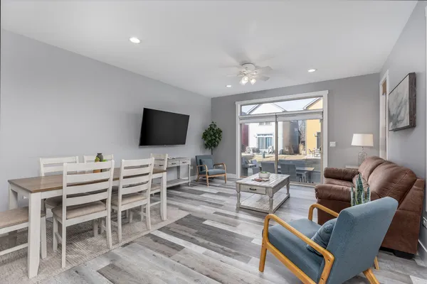 a living room with furniture and a large window with wooden floor