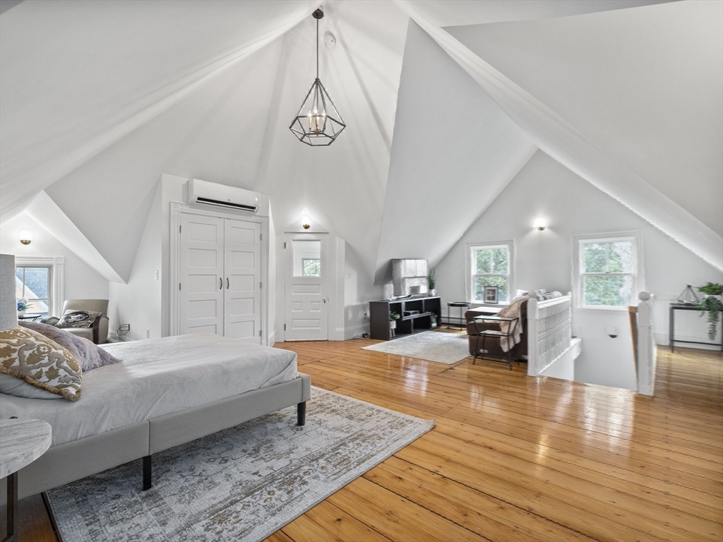 35 Frances Street Melrose, MA 02176 - Photo 28 of 42 a spacious bedroom with a bed a table and wooden floor