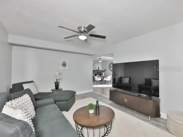 a living room with furniture and a wooden floor