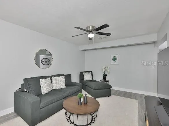 a living room with furniture a clock and a table