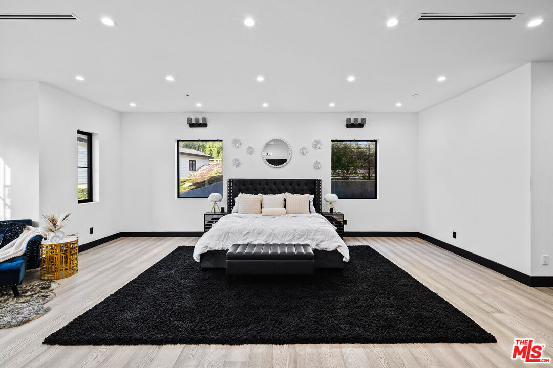 6006 Spring Valley Road Hidden Hills, CA 91302 - Photo 13 of 31 a spacious bedroom with a bed and a couch