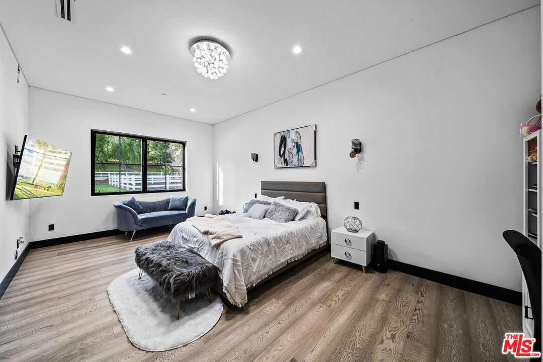 6006 Spring Valley Road Hidden Hills, CA 91302 - Photo 16 of 31 a bedroom with a bed window and couch