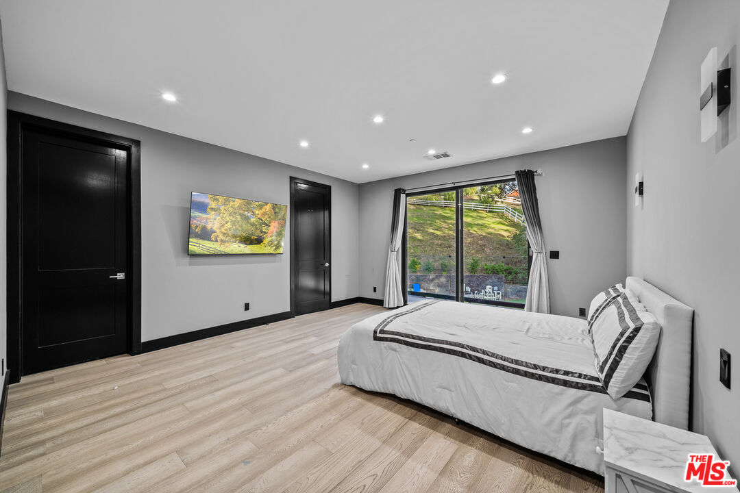 6006 Spring Valley Road Hidden Hills, CA 91302 - Photo 17 of 31 a spacious bedroom with a large bed and a window