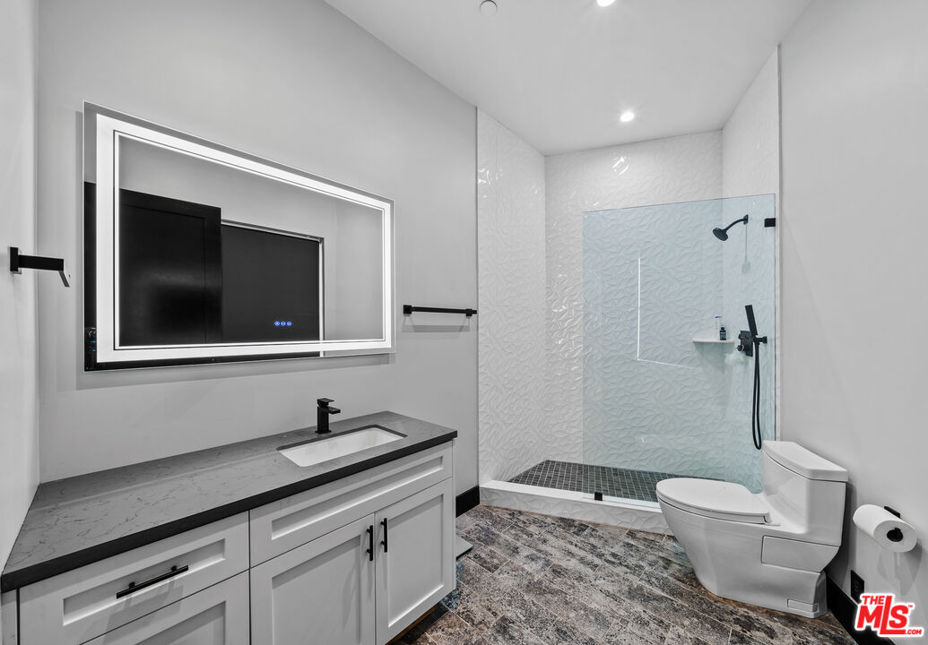 6006 Spring Valley Road Hidden Hills, CA 91302 - Photo 19 of 31 a bathroom with a granite countertop sink and a mirror
