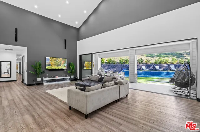 a large white kitchen with stainless steel appliances granite countertop a stove and a sink