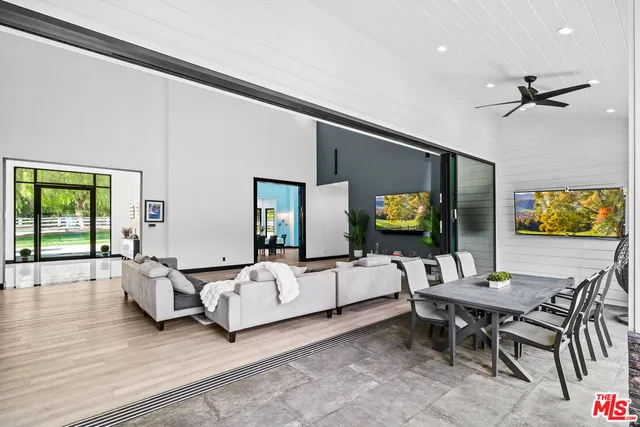 a large white kitchen with stainless steel appliances granite countertop a stove and a sink