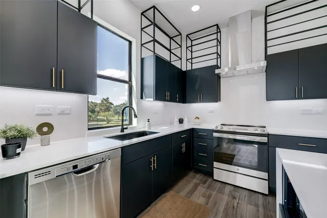 a kitchen with stainless steel appliances granite countertop a refrigerator a stove and a microwave