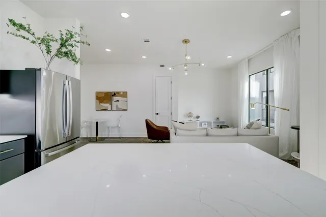 a kitchen with stainless steel appliances granite countertop a table chairs sink and cabinets