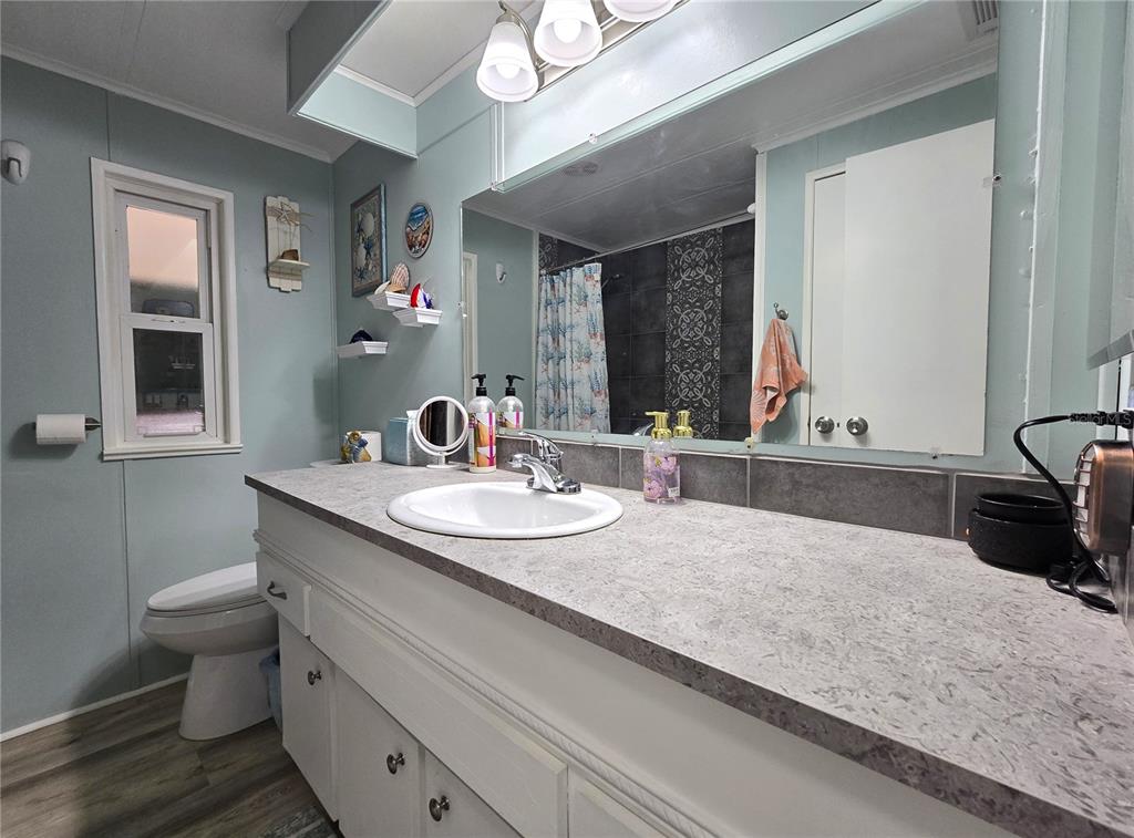 5619 Bayshore Road, Unit 435 Palmetto, FL 34221 - Photo 24 of 56 a bathroom with a granite countertop sink a toilet and mirror