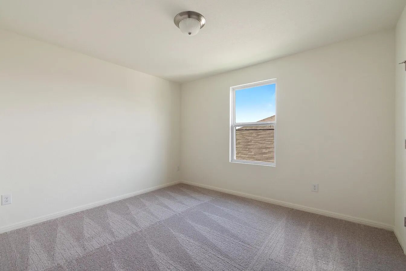 101 Aoudad Road Hutto, TX 78634 - Photo 30 of 39 A well-lit, neutral-toned room features soft carpeting and a clear window with blue skies.