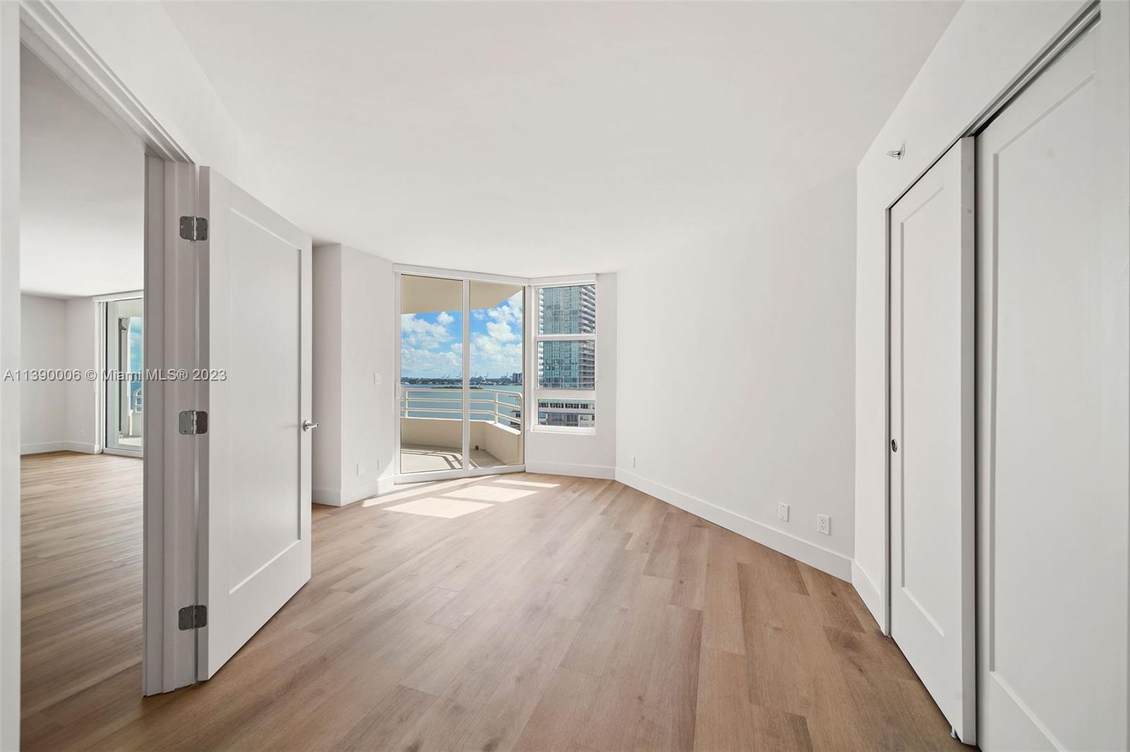 555 Northeast 34th Street, Unit 2307 Miami, FL 33137 - Photo 17 of 63 a view of an empty room with wooden floor and a window