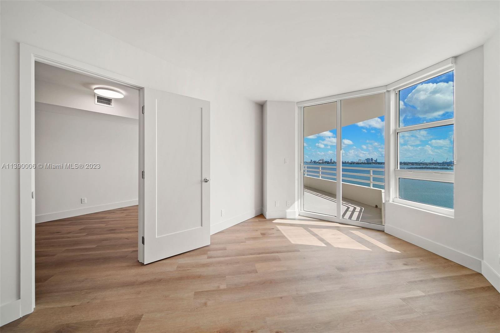 555 Northeast 34th Street, Unit 2307 Miami, FL 33137 - Photo 18 of 63 a view of an empty room with wooden floor and a window