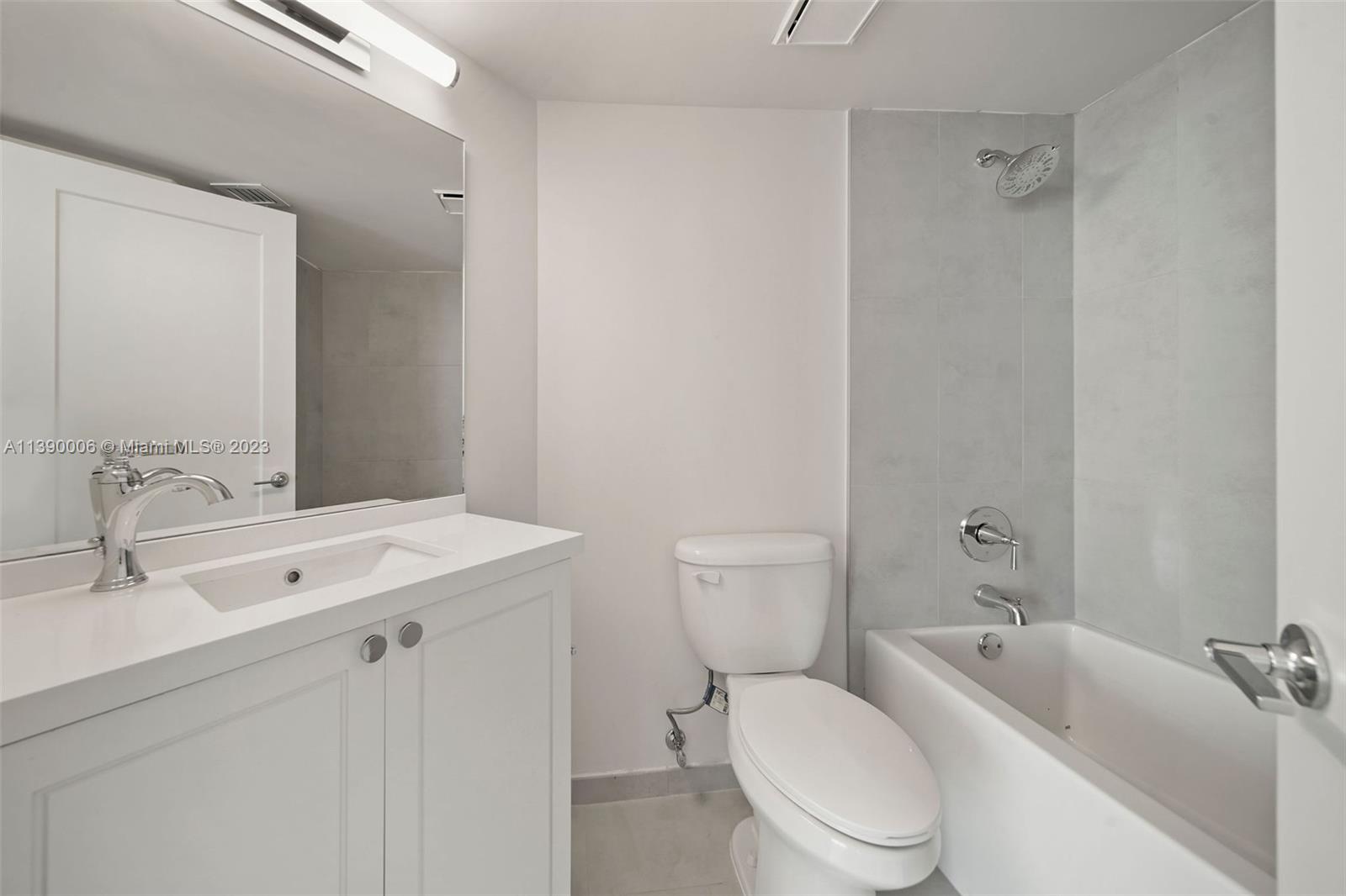 555 Northeast 34th Street, Unit 2307 Miami, FL 33137 - Photo 21 of 63 a bathroom with a toilet sink vanity tub and mirror