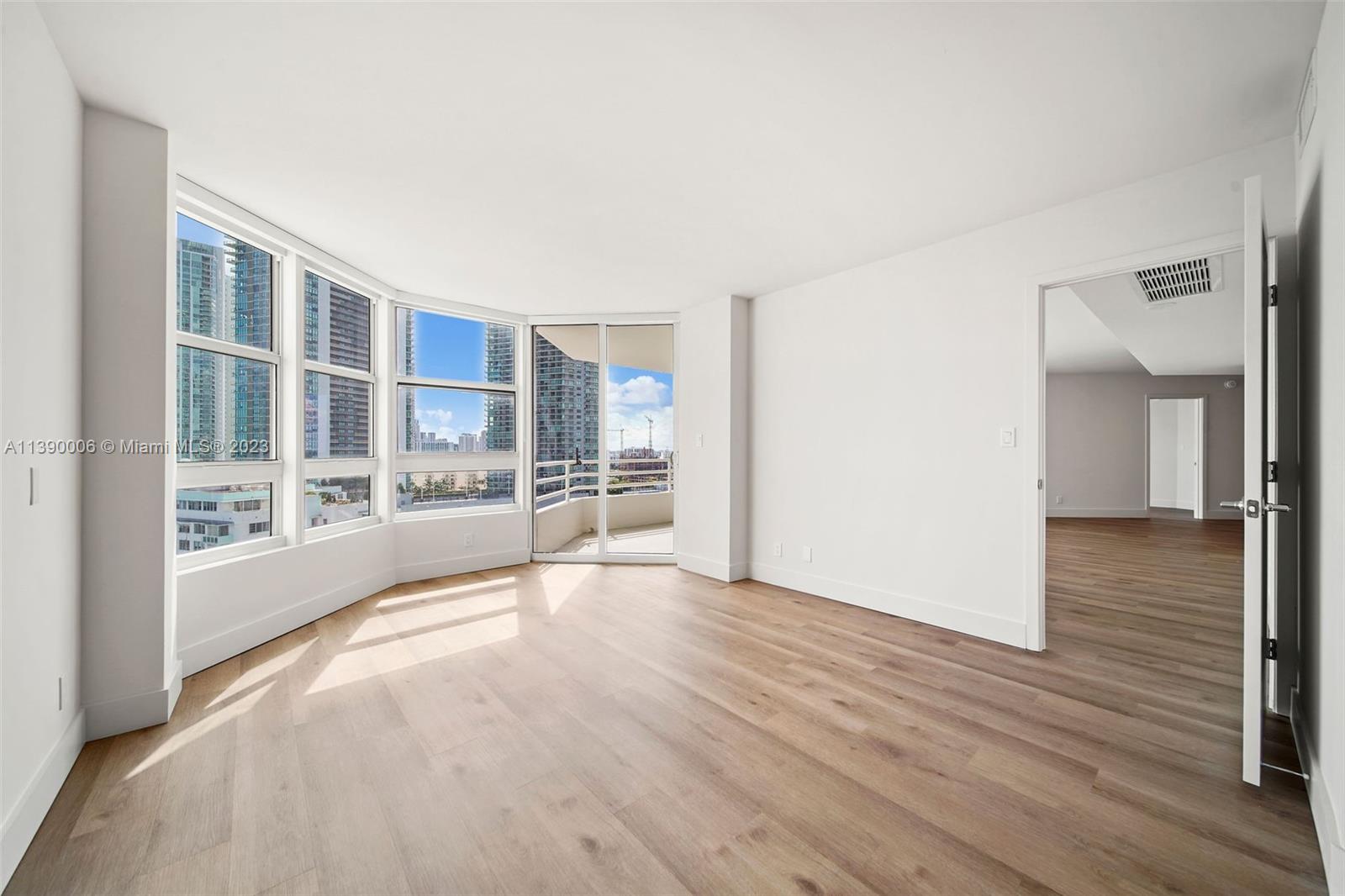 555 Northeast 34th Street, Unit 2307 Miami, FL 33137 - Photo 23 of 63 a view of an empty room with wooden floor and a window