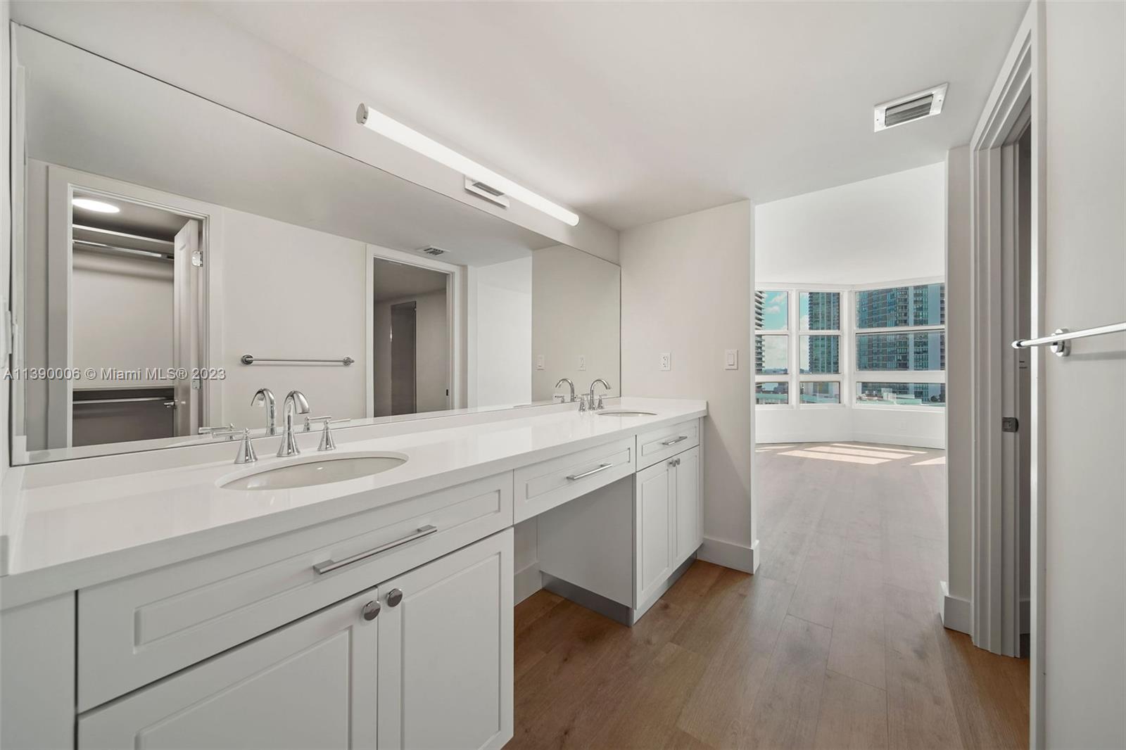 555 Northeast 34th Street, Unit 2307 Miami, FL 33137 - Photo 26 of 63 a spacious bathroom with a double vanity sink a mirror and a bathtub