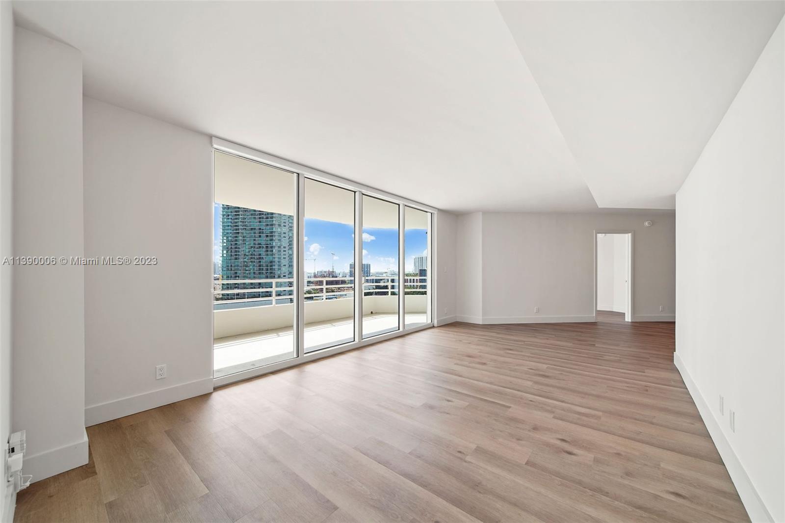 555 Northeast 34th Street, Unit 2307 Miami, FL 33137 - Photo 4 of 63 a view of an empty room with wooden floor and a window