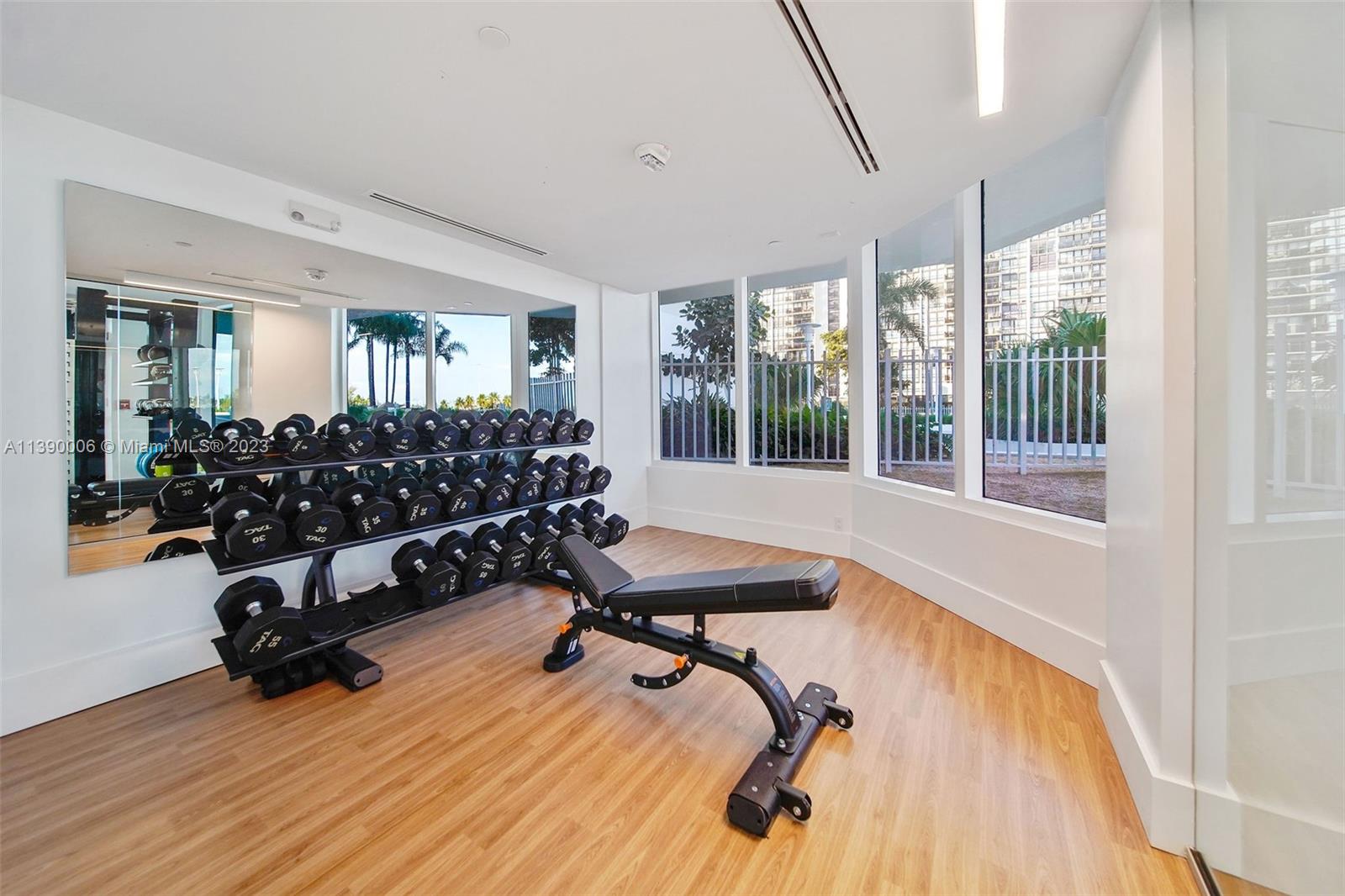 555 Northeast 34th Street, Unit 2307 Miami, FL 33137 - Photo 50 of 63 a room with gym equipment and a large window