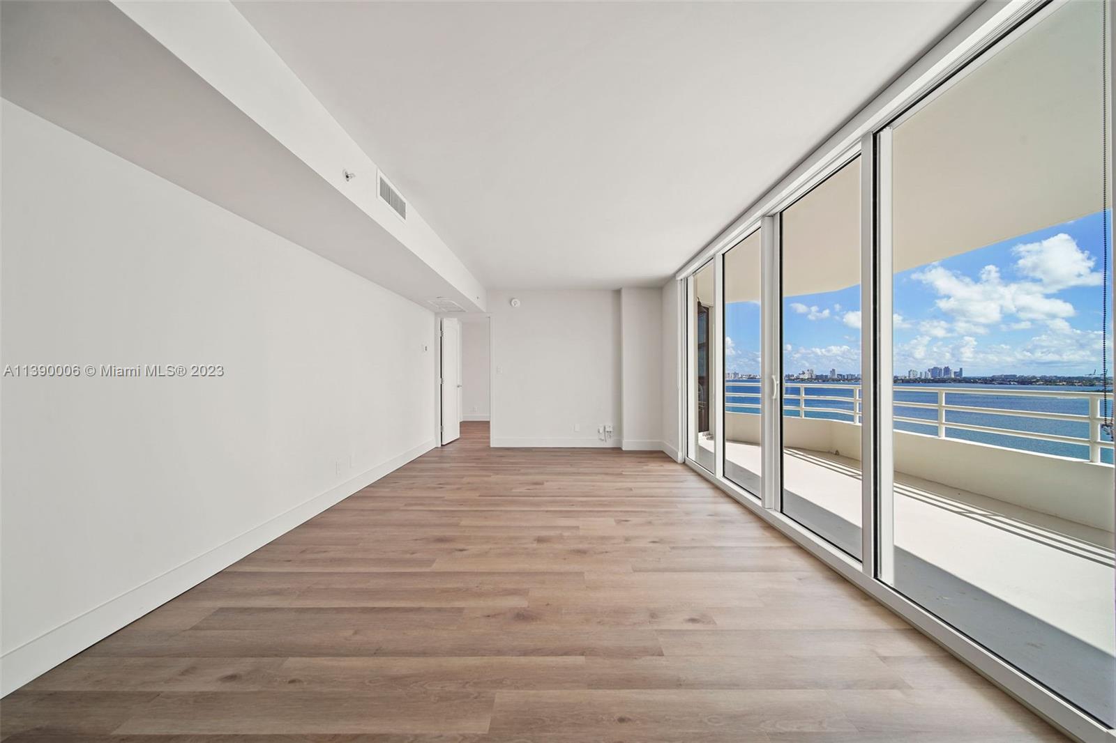 555 Northeast 34th Street, Unit 2307 Miami, FL 33137 - Photo 5 of 63 a view of an empty room with wooden floor and windows