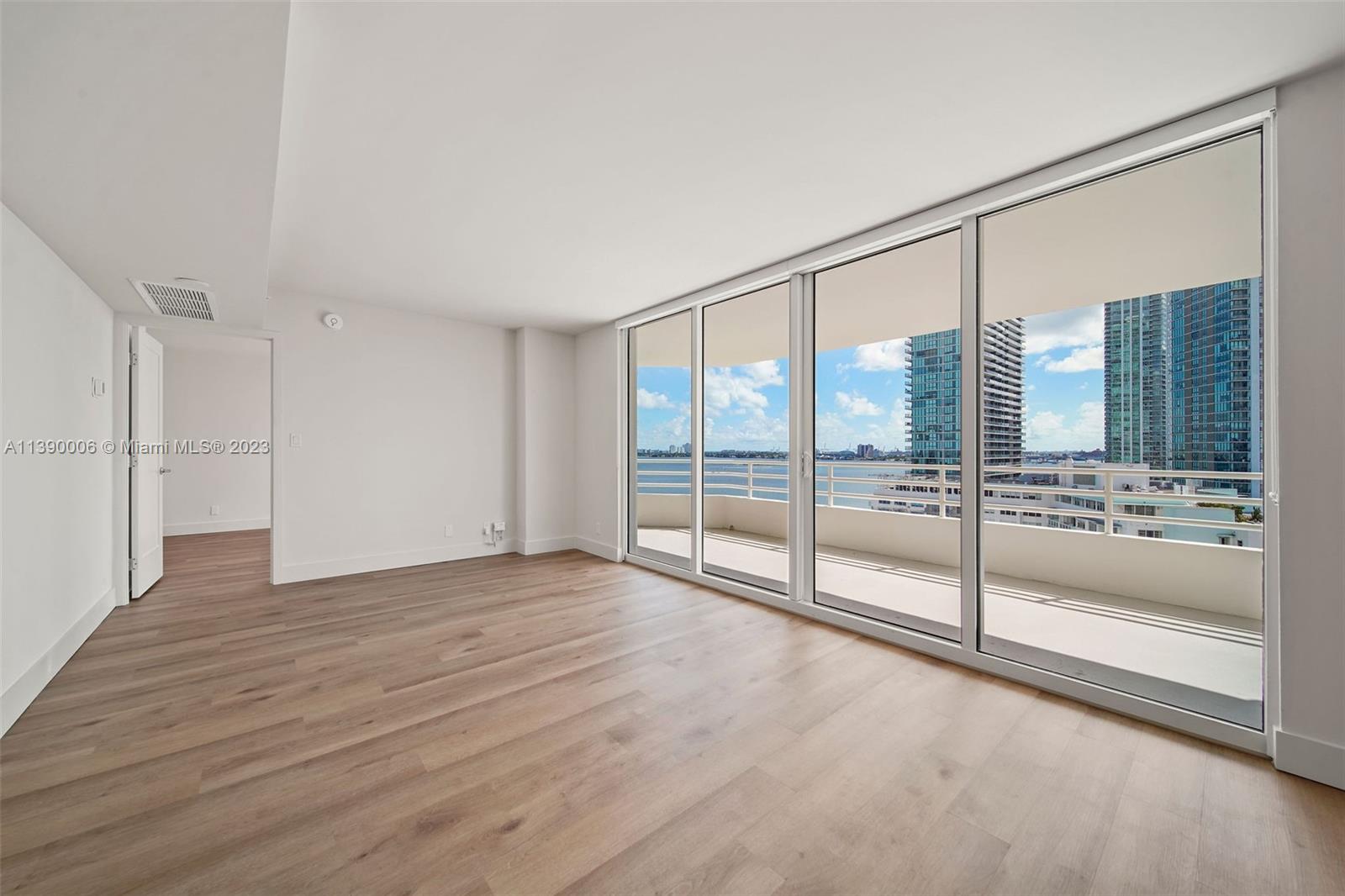 555 Northeast 34th Street, Unit 2307 Miami, FL 33137 - Photo 6 of 63 a view of an empty room with glass door and windows