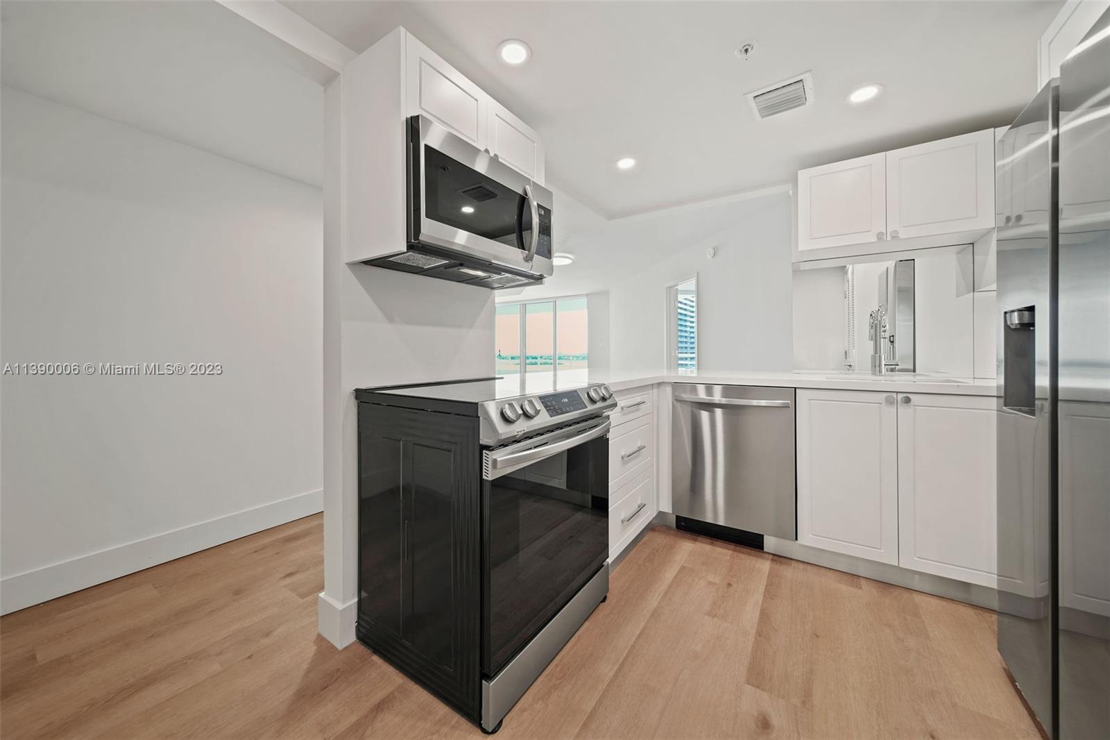 555 Northeast 34th Street, Unit 2307 Miami, FL 33137 - Photo 10 of 63 a kitchen with stainless steel appliances a stove microwave and sink