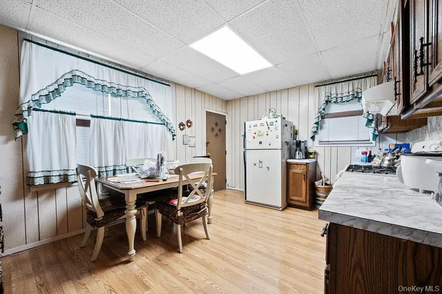 a kitchen with stainless steel appliances kitchen island granite countertop a table chairs and a refrigerator