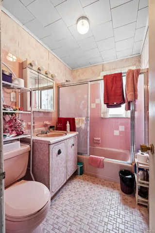 a bathroom with a granite countertop bathtub sink vanity mirror and toilet