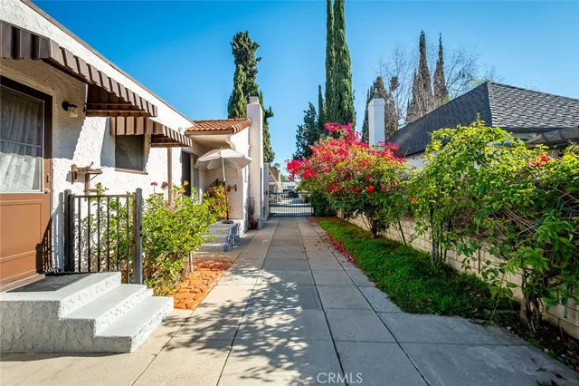 a view of a house with a yard and potted plants