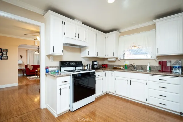 a kitchen with granite countertop white cabinets and white appliances