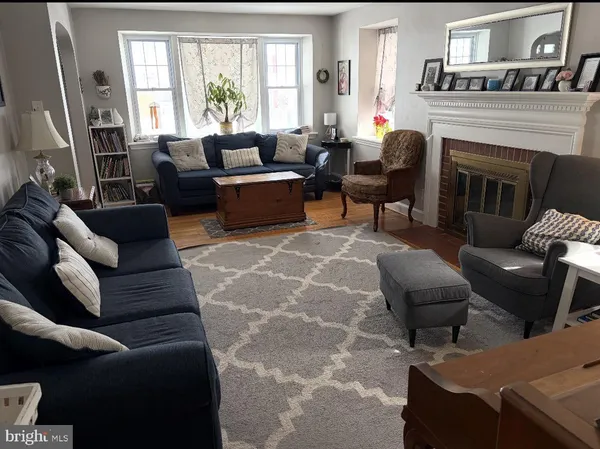 a living room with furniture a fireplace and a large window