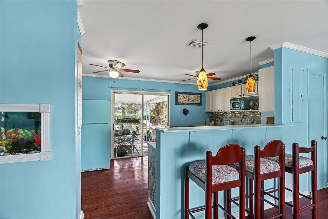 481 Warren Street Sebastian, FL 32958 - Photo 13 of 33 a dining room with furniture a chandelier and wooden floor