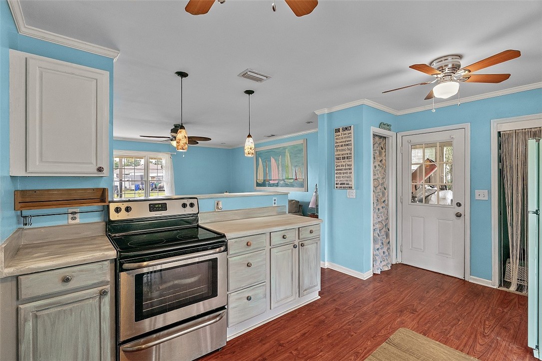 481 Warren Street Sebastian, FL 32958 - Photo 6 of 33 a kitchen with a stove and a wooden floor