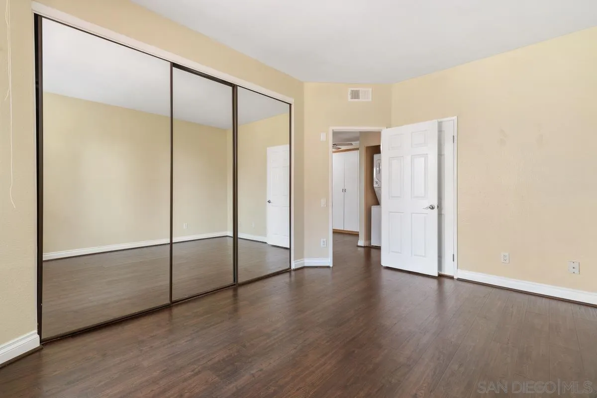 4049 Carmel View Road, Unit 75 San Diego, CA 92130 - Photo 8 of 13 a view of an empty room with wooden floor and a window