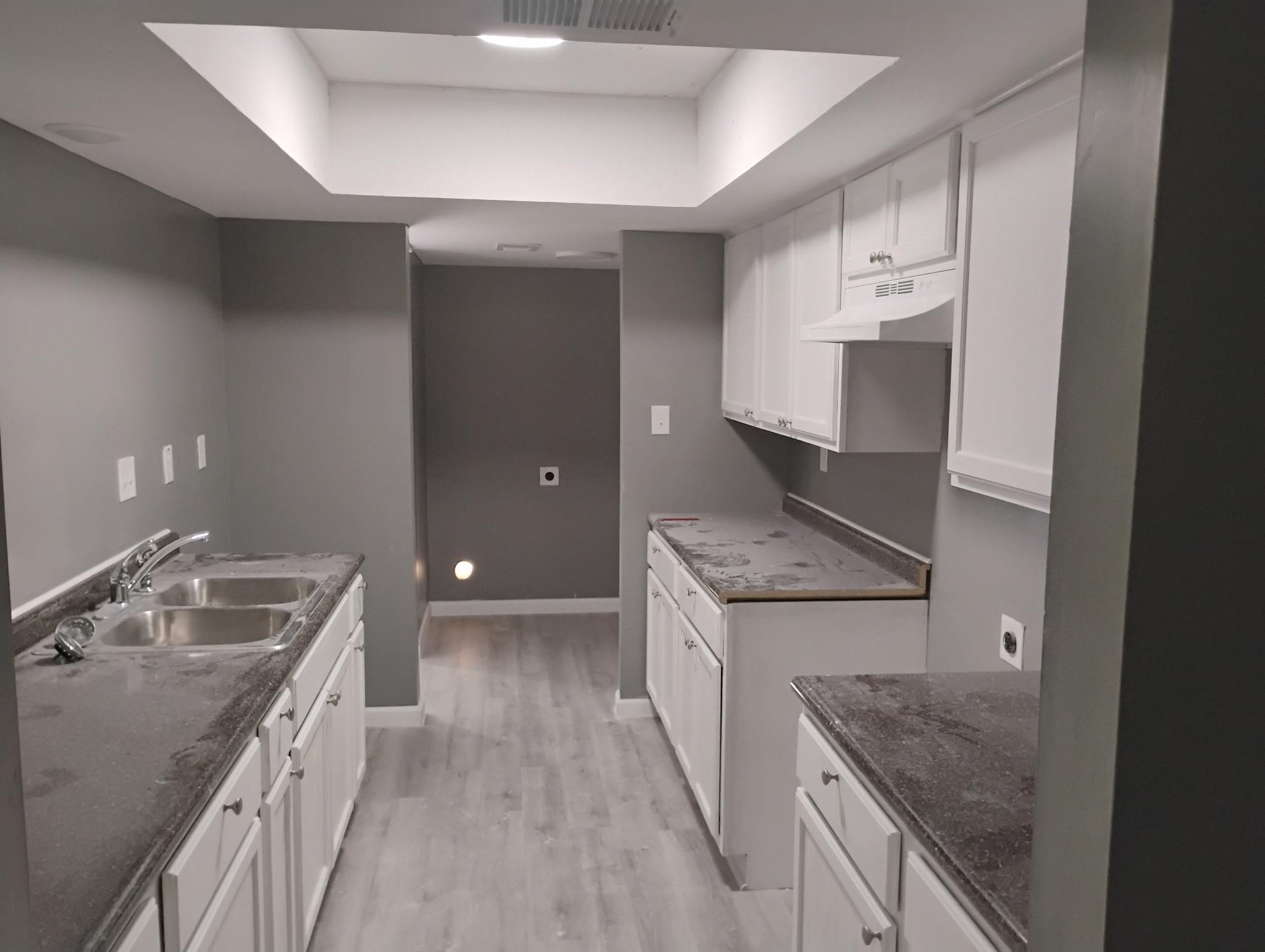 3340 Kirby Trees Place, Unit 3340 Memphis, TN 38115 - Photo 7 of 16 Kitchen with white cabinets, a raised ceiling, light wood-type flooring, and under cabinet range hood