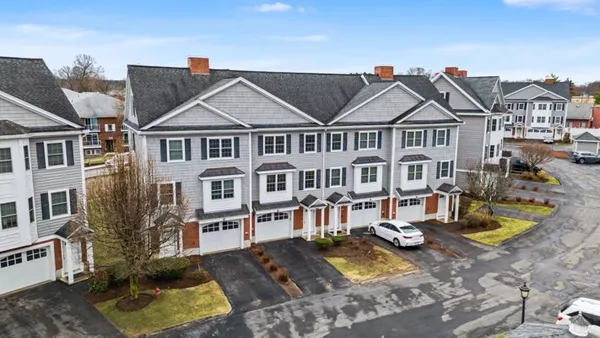 a view of a big house with large windows and a yard