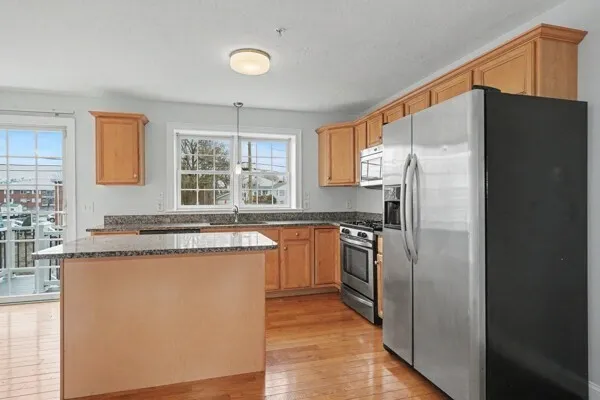 a kitchen with granite countertop a refrigerator and a sink