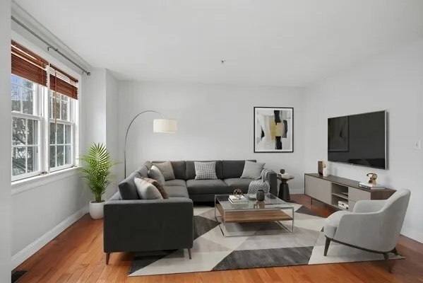 a living room with furniture wooden floor and a flat screen tv