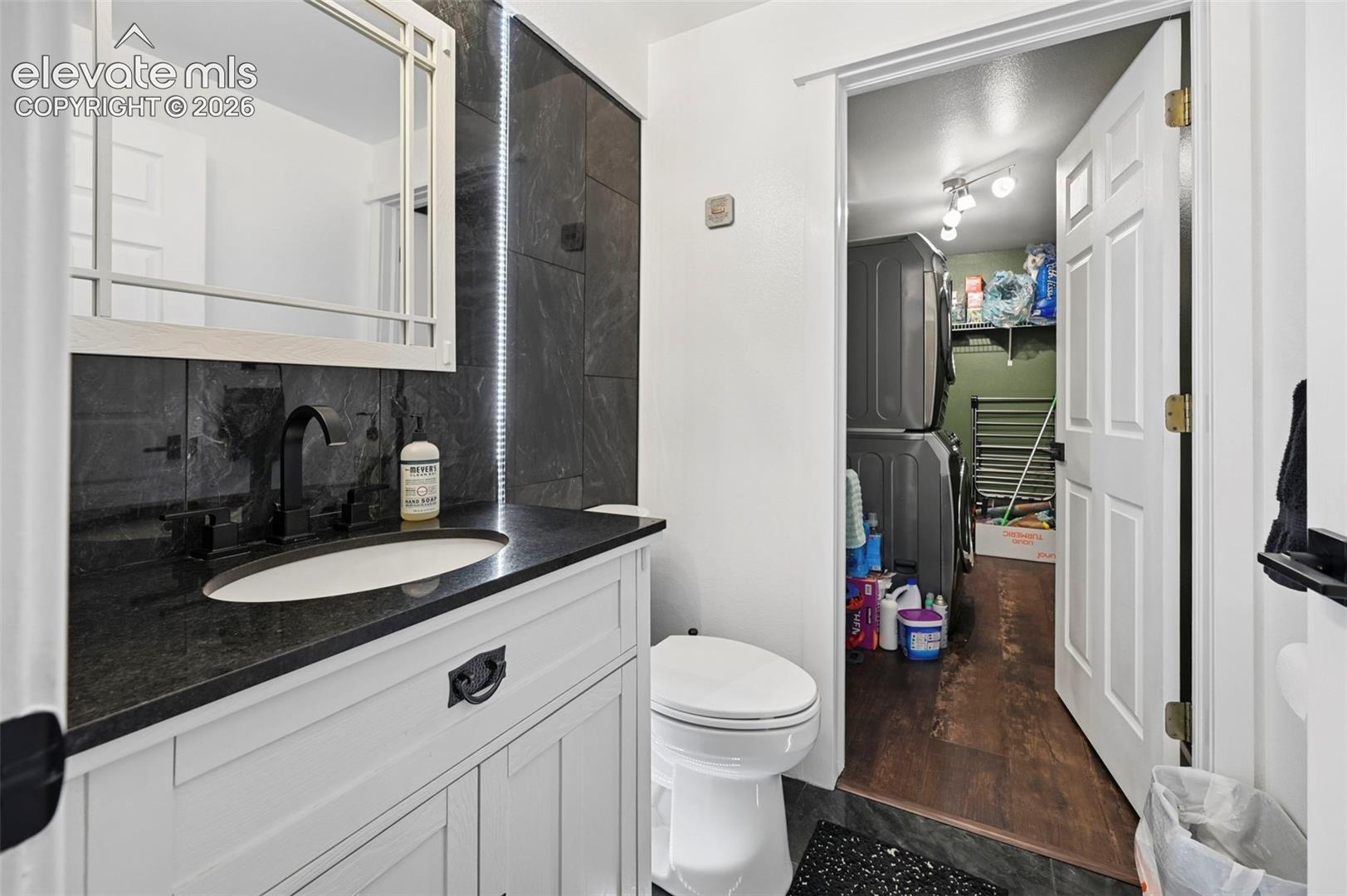 8347 Tibbs Road Peyton, CO 80831 - Photo 6 of 38 White shaker-style vanity with a dark countertop and integrated sink