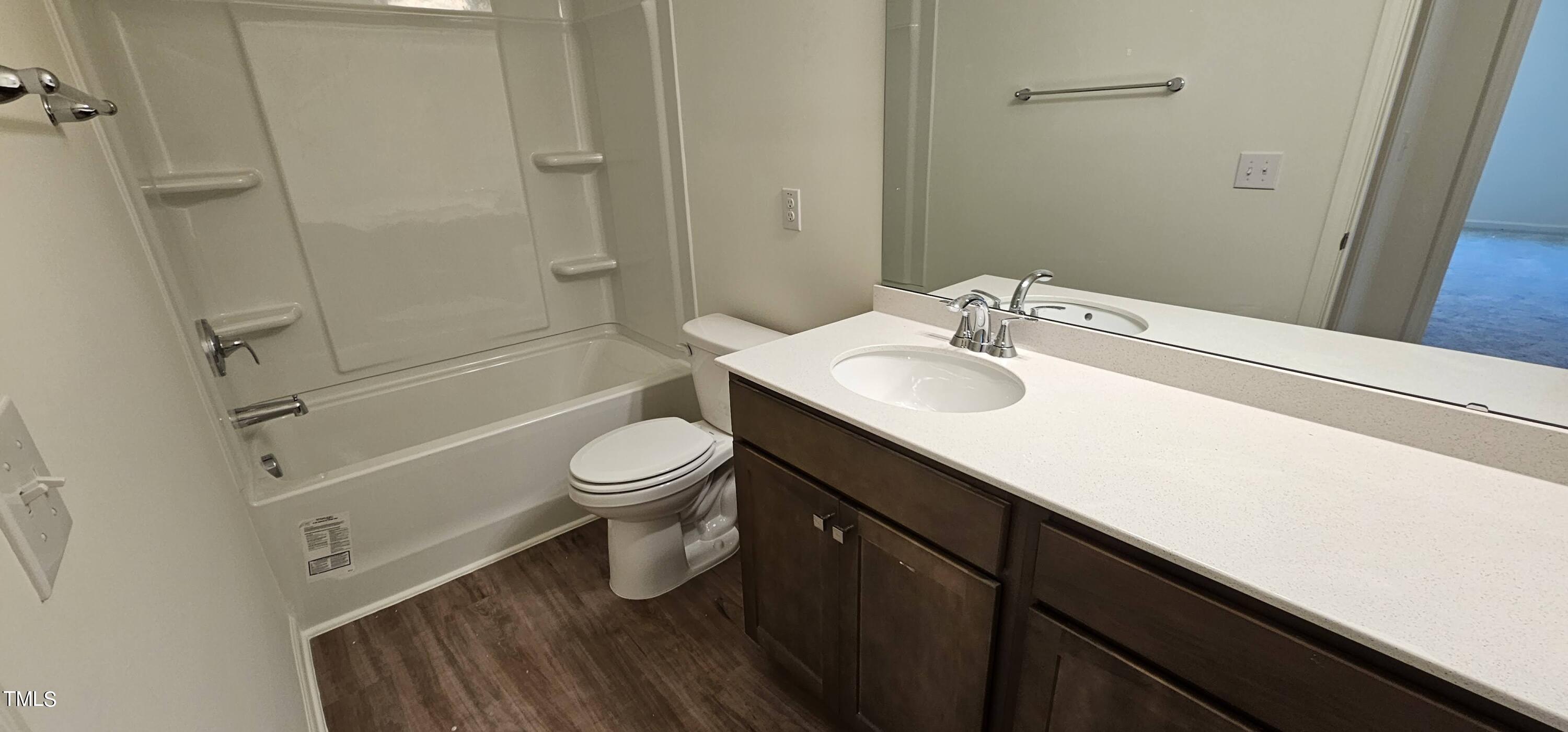1409 Underbrush Drive Durham, NC 27703 - Photo 12 of 21 a bathroom with a sink a toilet a mirror and shower